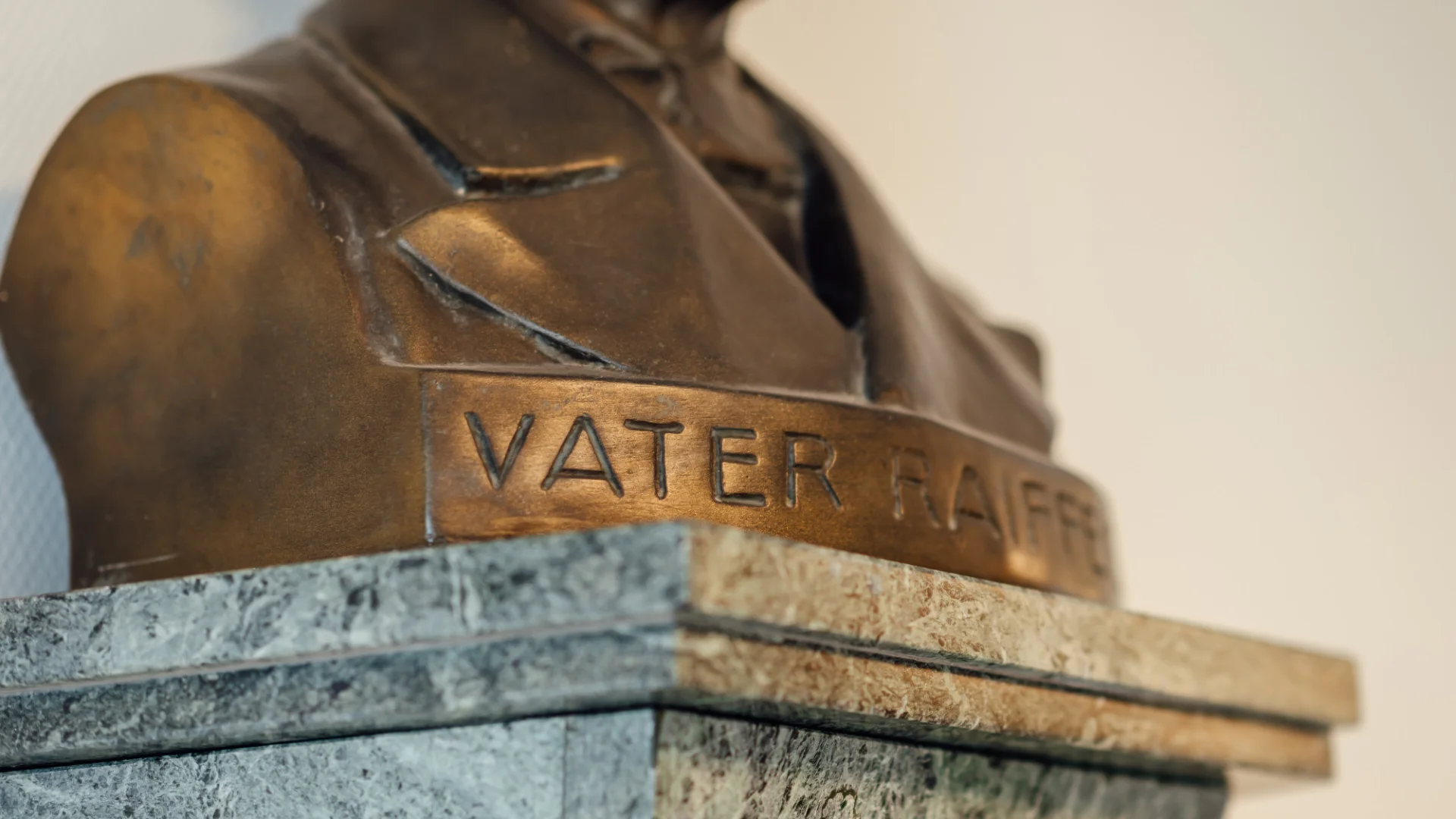 Detailaufnahme einer Raiffeisen-Büste mit der Inschrift „Vater Raiffeisen“. Das Bild steht für die genossenschaftlichen Wurzeln und die Geschichte des Genossenschaftsverbands Weser-Ems.
