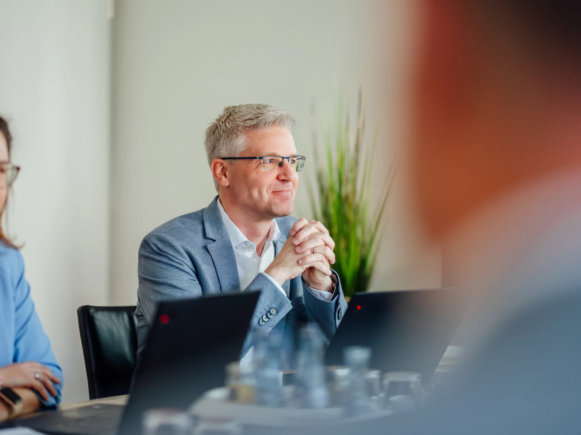 Mehrere Personen sitzen mit Laptops in einem Besprechungsraum und hören einander zu. Das Bild steht für Personalberatung, Personalmanagement sowie Führungs- und Personalarbeit beim Genossenschaftsverband Weser-Ems.