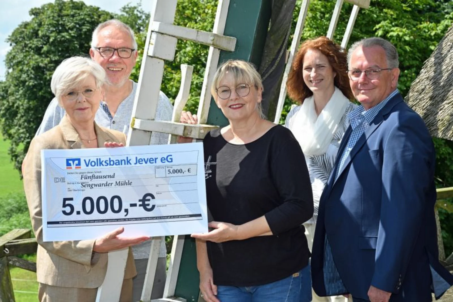Susanne Leiting von der Volksbank Jever (v. l.) überreichte den Scheck an Günter Hoffmann, Vorsitzender Heimatverein, Müllerin Kerstin Tiemann, Kerstin Gleve, Untere Denkmalschutzbehörde, und Reiner Hinrichs, Mühlenbeauftragter Heimatverein.